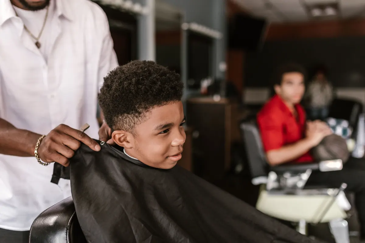 Niño sonriendo mientras le cortan el pelo