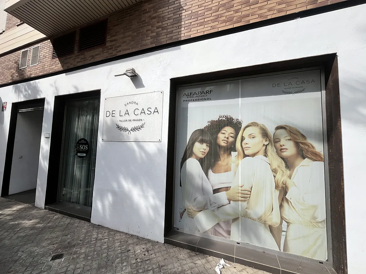 Fachada del salón en la Avinguda del Cardenal Benlloch: rótulo con el logo de Sandra de la Casa Taller de Imagen junto a un escaparate con un cartel de cuatro mujeres