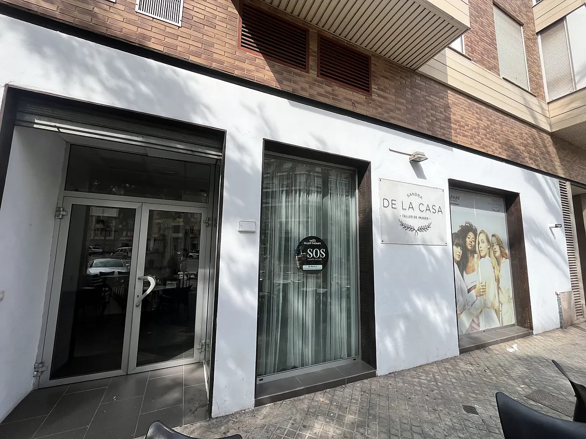 Entrada del salón: puerta de cristal y rótulo de Sandra de la Casa Taller de Imagen en la fachada blanca