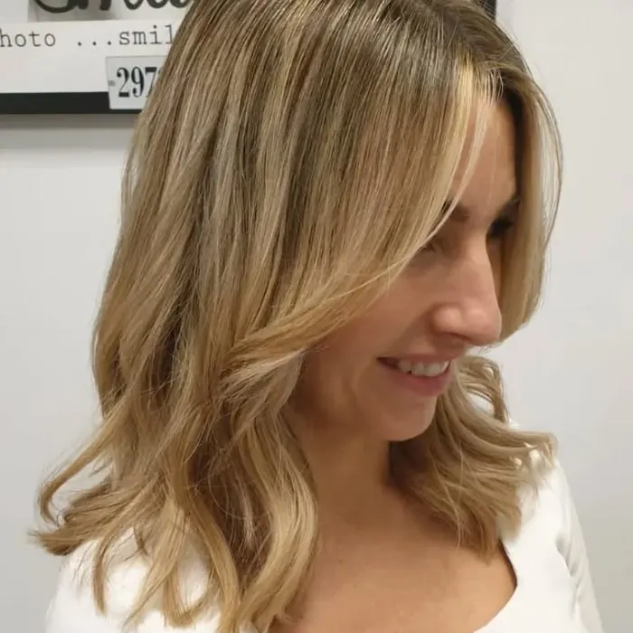 Trabajo del salón publicado en el Instagram de Sandra: media melena rubia con mechas y ondas, vista de perfil