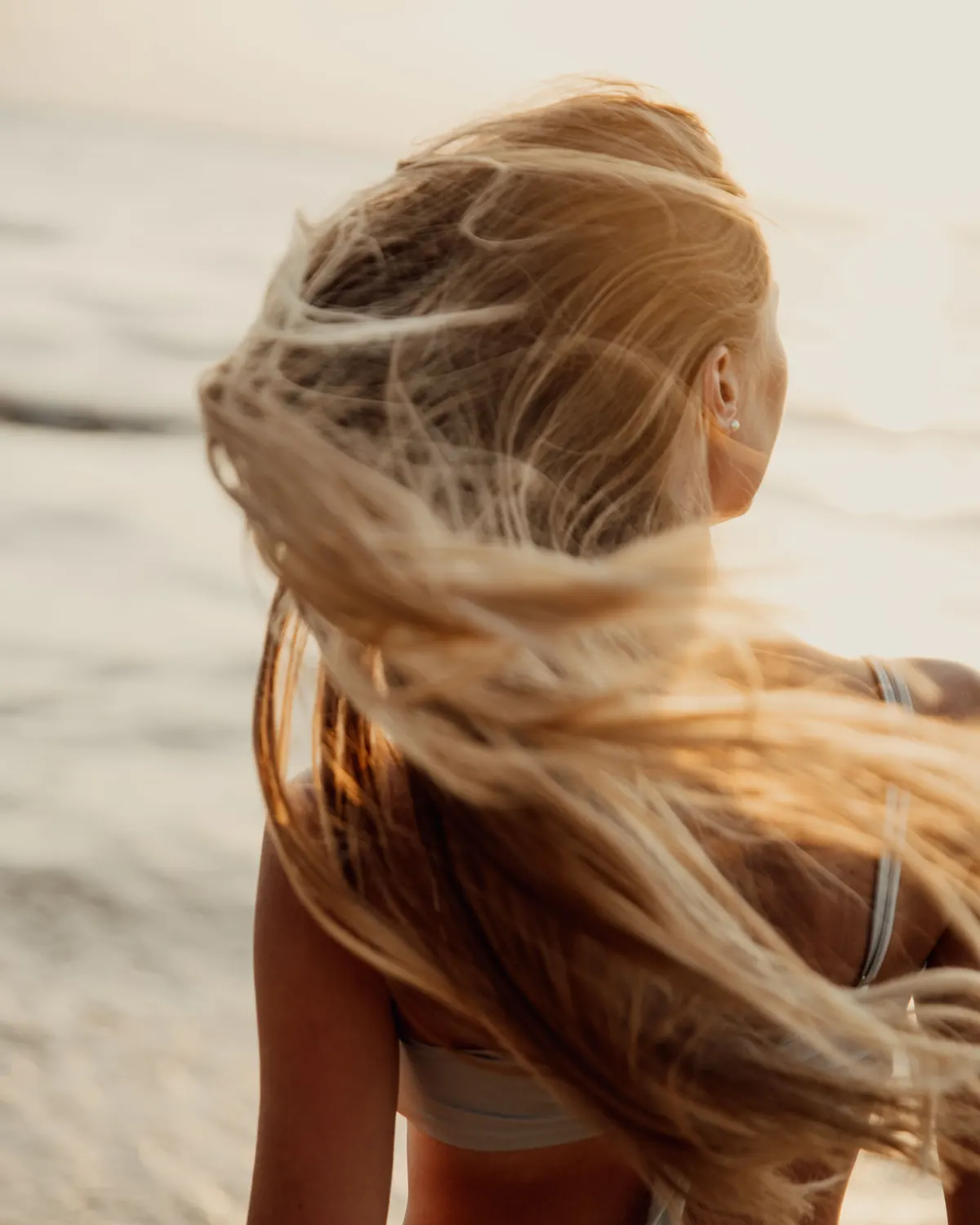 Melena rubia al viento en la playa