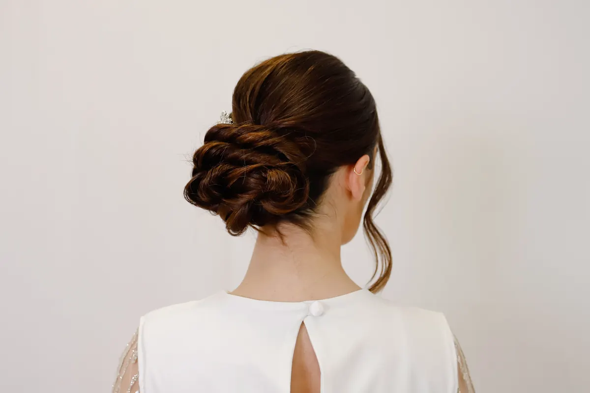 Recogido bajo elegante sobre un vestido blanco, visto desde atrás